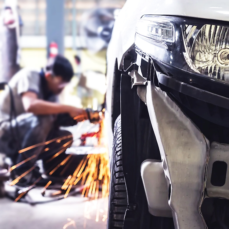 Certified technicians performing collision repair on a car at DNA Collision Center in Houston